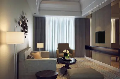 a living room with a couch and a chair and a television at JW Marriott Kuala Lumpur in Kuala Lumpur