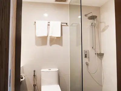a bathroom with a toilet and a shower with towels at Starus Hotel Bukit Bintang in Kuala Lumpur