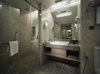 a bathroom with a sink and a glass shower at Sunway Putra Hotel Kuala Lumpur in Kuala Lumpur