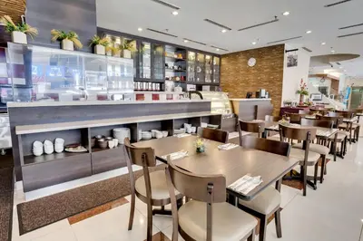 a restaurant with tables and chairs and a counter at Prescott Hotel Kuala Lumpur Medan Tuanku in Kuala Lumpur