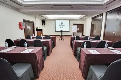 a conference room with tables and chairs and a screen at Prescott Hotel Kuala Lumpur Medan Tuanku in Kuala Lumpur