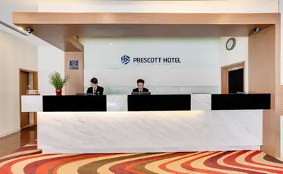 two people sitting at a reception desk in a room at Prescott Hotel Kuala Lumpur Medan Tuanku in Kuala Lumpur