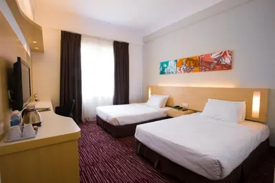a hotel room with two beds and a television at Prescott Hotel Kuala Lumpur Medan Tuanku in Kuala Lumpur