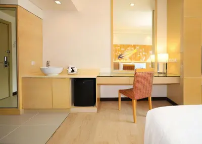 a bathroom with a sink and a desk with a chair at ANSA Hotel Kuala Lumpur in Kuala Lumpur