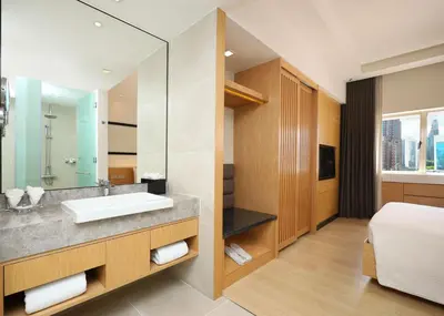a bathroom with a sink and a bed and a mirror at ANSA Hotel Kuala Lumpur in Kuala Lumpur
