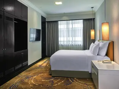 a bedroom with a large white bed and a television at Pullman Kuala Lumpur City Centre Hotel & Residences in Kuala Lumpur
