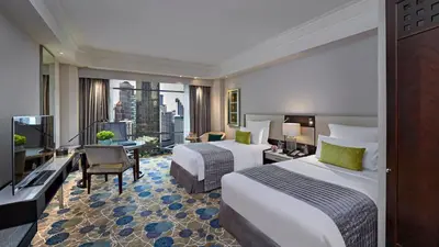 a hotel room with two beds and a large window at Mandarin Oriental, Kuala Lumpur in Kuala Lumpur
