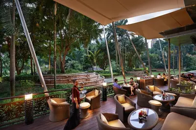a restaurant with people sitting in chairs and tables at Mandarin Oriental, Kuala Lumpur in Kuala Lumpur