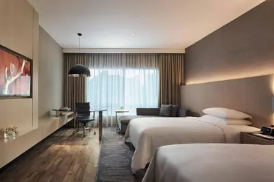 a hotel room with two beds and a desk at Renaissance Kuala Lumpur Hotel & Convention Centre in Kuala Lumpur
