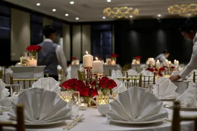 a dining room with white tables with red flowers and candles at AC Hotel by Marriott Kuala Lumpur in Kuala Lumpur