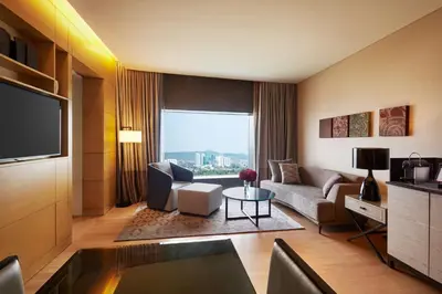 a living room with a couch and a tv at Hilton Kuala Lumpur in Kuala Lumpur