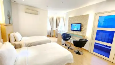 a hotel room with two beds and a tv at Holiday Place Kuala Lumpur in Kuala Lumpur