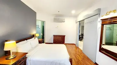 a bedroom with a white bed and a mirror at Holiday Place Kuala Lumpur in Kuala Lumpur