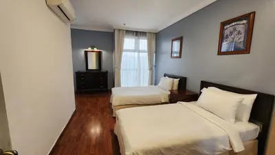 a hotel room with two beds and a window at Holiday Place Kuala Lumpur in Kuala Lumpur