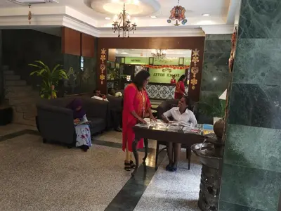 a woman standing in front of a table in a lobby at Palace Hotel in Kuala Lumpur