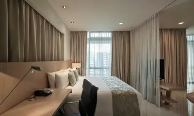 a hotel room with a bed and a desk at PARKROYAL Serviced Suites Kuala Lumpur in Kuala Lumpur