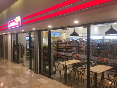 a restaurant with tables and chairs in a store at Homely Apartment with Great Facilities and Free Parking in Kuala Lumpur