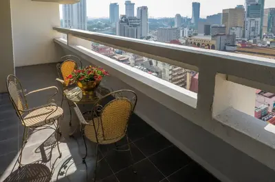 a balcony with chairs and a table with flowers on it at The 5 Elements Hotel Chinatown Kuala Lumpur in Kuala Lumpur