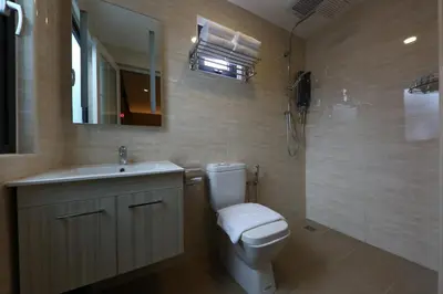 a bathroom with a toilet and a sink and a mirror at M&M Hotel in Kuala Lumpur