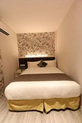 a bedroom with a large white bed with a headboard at M&M Hotel in Kuala Lumpur
