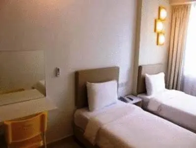 a hotel room with two beds and a window at YY38 Hotel in Kuala Lumpur