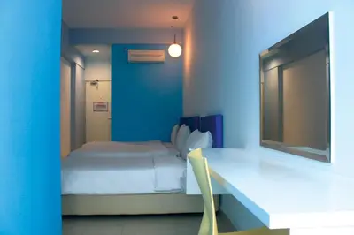 a blue room with a bed and a table with a chair at YY38 Hotel in Kuala Lumpur