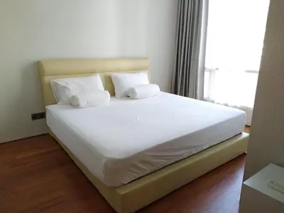 a bed with white sheets and pillows in a room at Soho Suites KLCC by LX Suites in Kuala Lumpur
