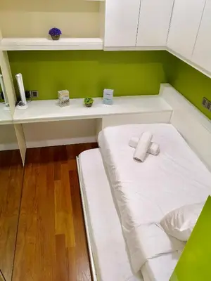 a small room with a bed and a desk at Soho Suites Klcc By Pnut KLCC VIEW in Kuala Lumpur