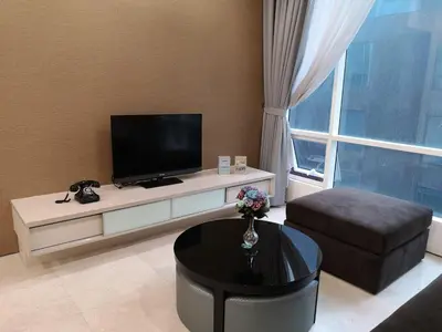 a living room with a flat screen tv and a table at Soho Suites Klcc By Pnut KLCC VIEW in Kuala Lumpur