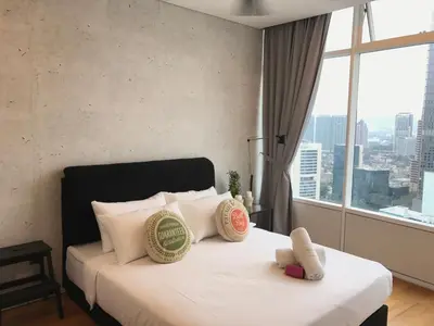 a bedroom with a bed with white pillows and a window at VORTEX SUITES KLCC by PNUT With NETFLIX in Kuala Lumpur