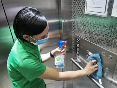 a person wearing a mask and cleaning a machine at Leo Palace Hotel New Wing, WTC Kuala Lumpur in Kuala Lumpur