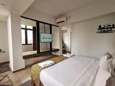a bedroom with a bed and a tv on the wall at Leo Palace Hotel New Wing, WTC Kuala Lumpur in Kuala Lumpur