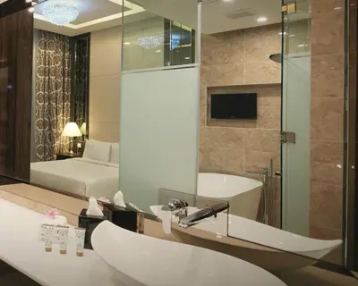 a bathroom with a tub and a sink and a bed at Dorsett Residences Bukit Bintang @Dorsett Kuala Lumpur in Kuala Lumpur