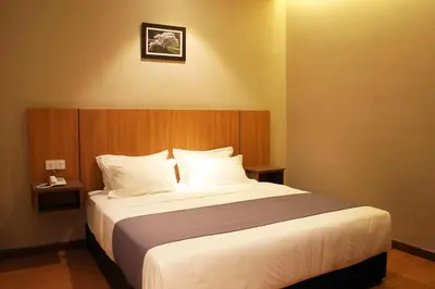 a bedroom with a large bed with white pillows at Ahyu Hotel in Kuala Lumpur