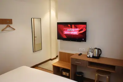a room with a bed and a tv on the wall at Ahyu Hotel in Kuala Lumpur
