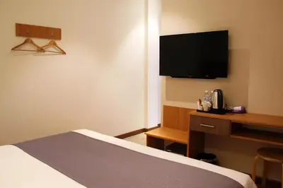 a hotel room with a bed and a flat screen tv at Ahyu Hotel in Kuala Lumpur