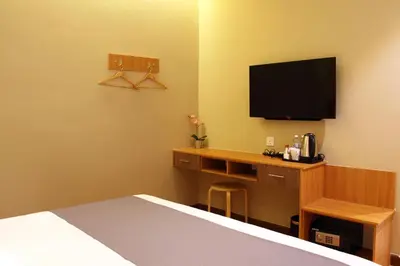 a hotel room with a bed and a desk with a television at Ahyu Hotel in Kuala Lumpur