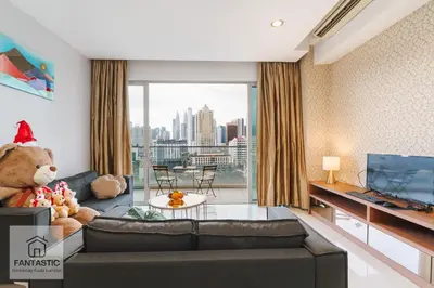 a living room with a large teddy bear sitting on a couch at Regalia Residence @ KLCC View Sky Pool by MC in Kuala Lumpur