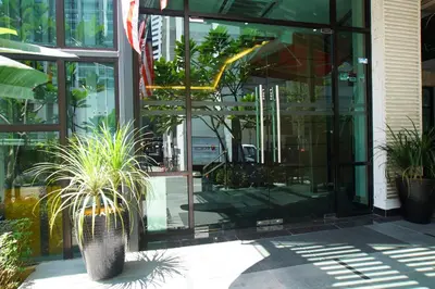 a glass building with potted plants in front of it at Vivids Hotel in Kuala Lumpur