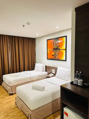 a hotel room with two beds and a desk at Frenz Hotel Kuala Lumpur in Kuala Lumpur