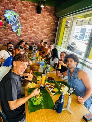 a group of people sitting at a table in a restaurant at Travelogue Guest House in Kuala Lumpur