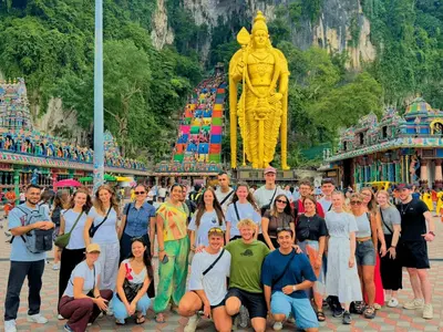 a group of people posing in front of a statue at Travelogue Guest House in Kuala Lumpur