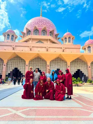 a group of monks posing in front of a mosque at Travelogue Guest House in Kuala Lumpur