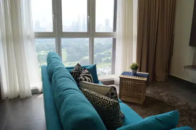 a blue couch in a living room with a large window at Sentrio Pandan Kuala Lumpur in Kuala Lumpur