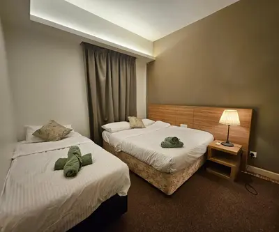 a hotel room with two beds with towels on them at Royal Suite in Kuala Lumpur