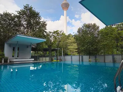 a swimming pool with a tower in the background at Royal Suite in Kuala Lumpur