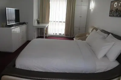 a bedroom with a large white bed and a television at FnF Suite @ Time Square in Kuala Lumpur