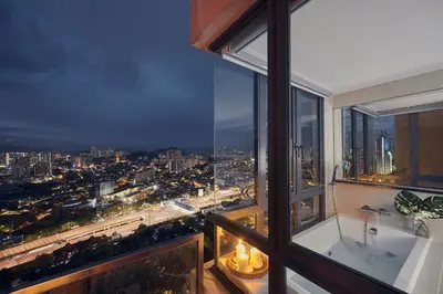 a bathroom with a view of a city at night at TRILLION SUITES by SLG in Kuala Lumpur