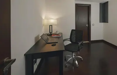 a desk with a laptop and a chair in a room at TRILLION SUITES by SLG in Kuala Lumpur