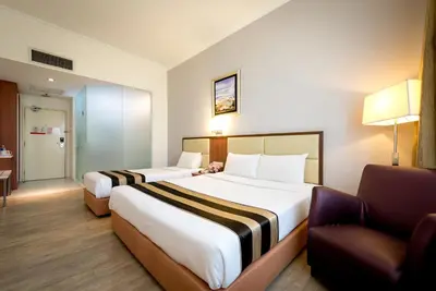 a hotel room with two beds and a chair at Hotel Sentral Pudu @ City Centre / Bukit Bintang in Kuala Lumpur
